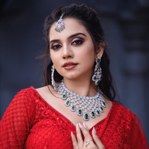 Close-up photo of a Girl in red beautiful gown with royal dark and gold background